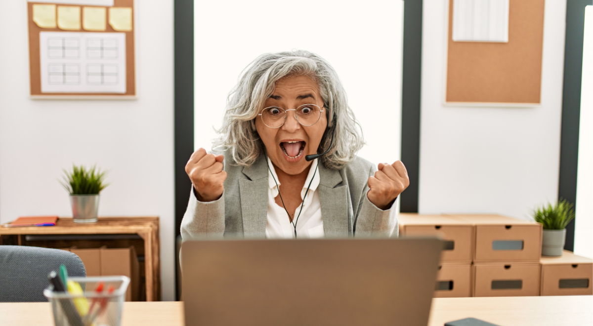 educator celebrating at laptop